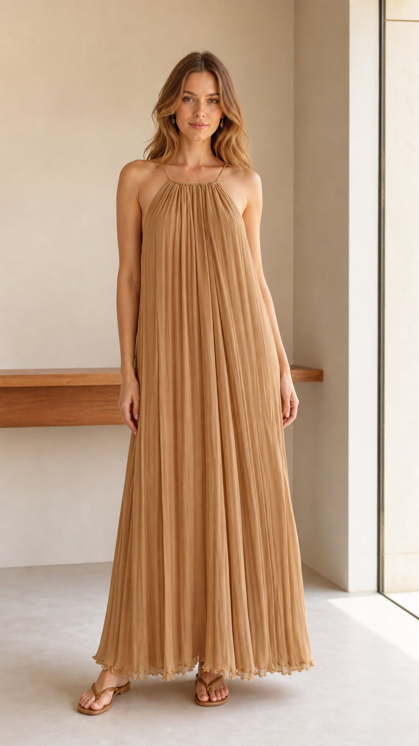 Model wearing camel pleated halter maxi dress, front view