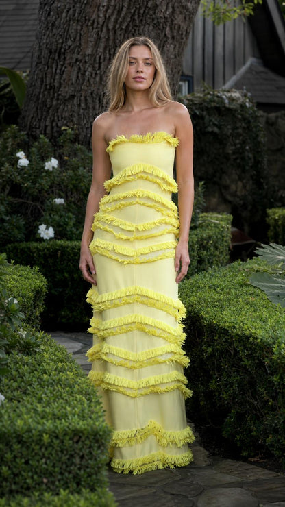 Model wearing yellow tiered fringe strapless maxi dress from front