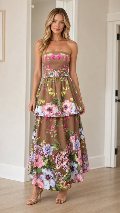 Front view of woman wearing brown floral strapless tiered maxi dress