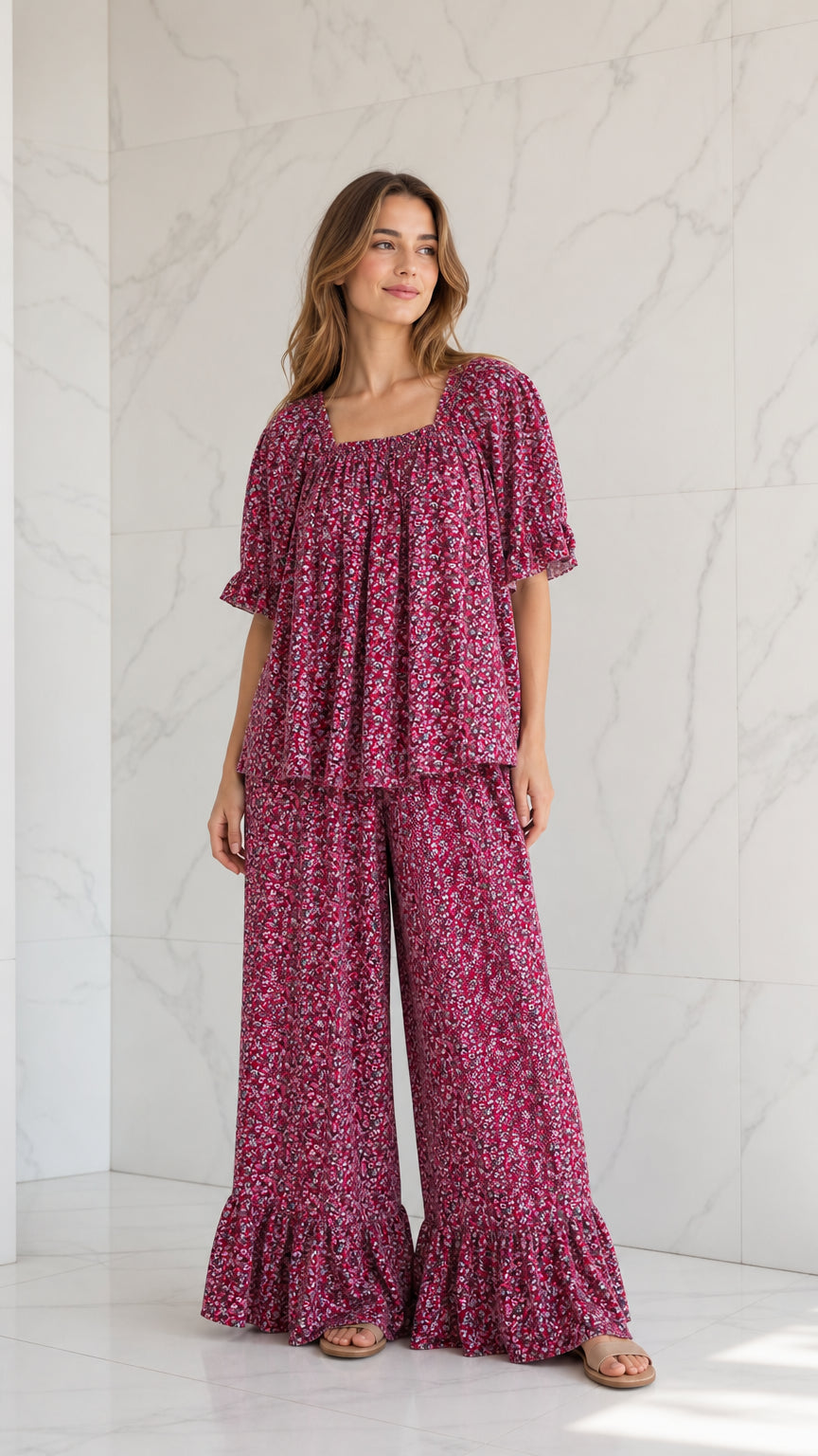 Full front view of model wearing magenta ditsy floral top and matching ruffle-hem wide-leg pants set