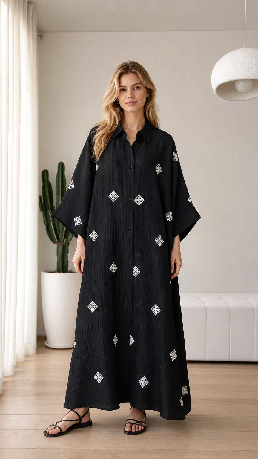 Front view of black embroidered button-down maxi shirt dress on model
