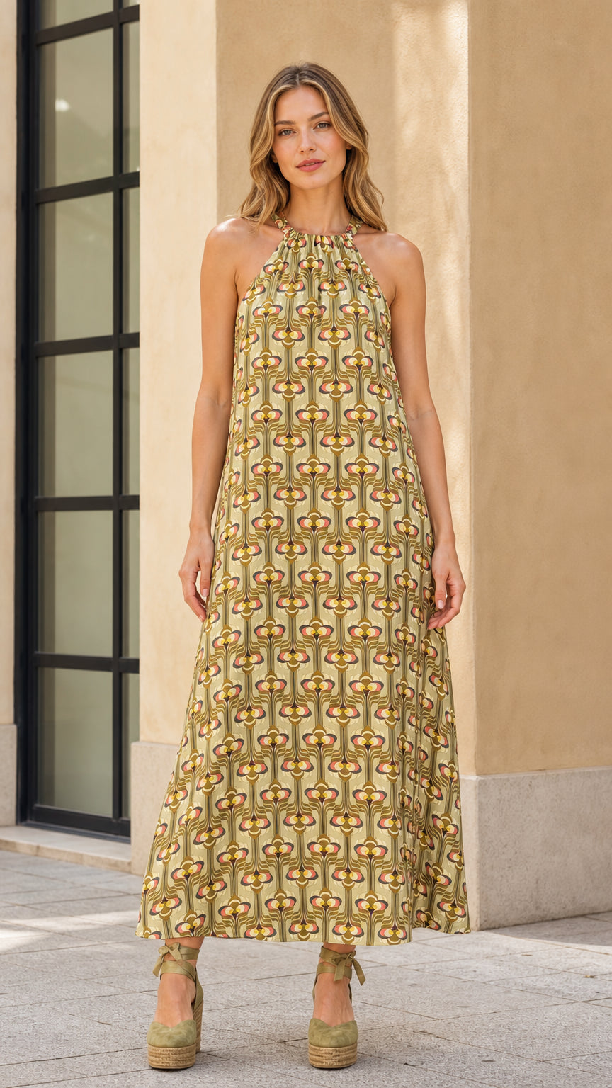 Front view of model wearing olive geo print halter maxi dress with wedges