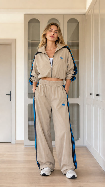 Model wearing khaki tan cropped windbreaker jacket and wide-leg track pants set front view