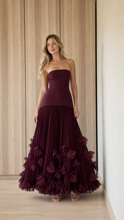 Front view of woman wearing burgundy strapless pleated ruffle evening gown