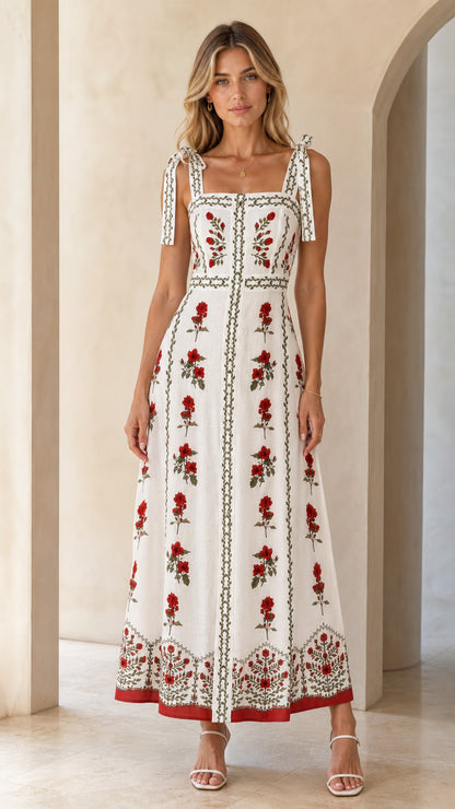 Front view of woman wearing white floral embroidered tie-strap maxi dress