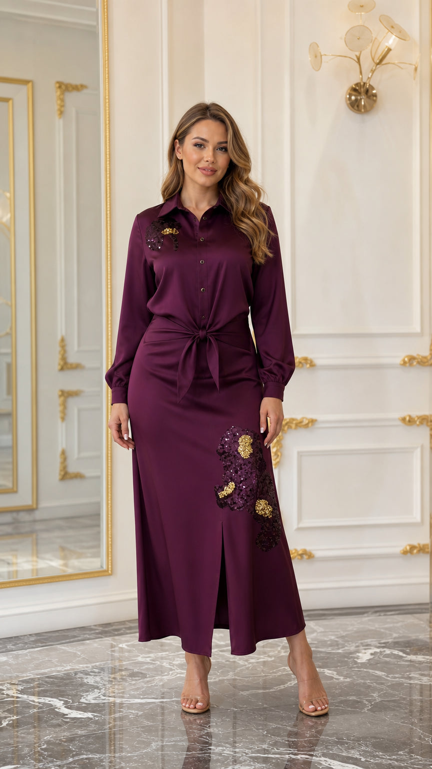 Woman wearing a burgundy satin-look embroidered maxi shirt dress with tie waist and front slit