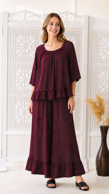 Front view of woman wearing burgundy polka dot two-piece set with ruffle top and wide-leg pants