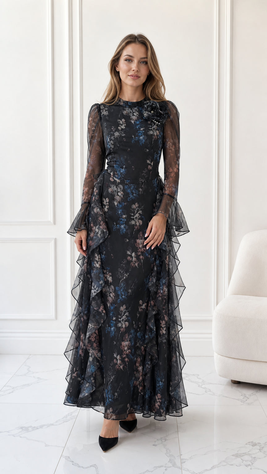Front full-length view of model wearing black floral long sleeve chiffon maxi dress with cascading ruffles