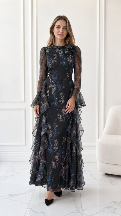 Front full-length view of model wearing black floral long sleeve chiffon maxi dress with cascading ruffles