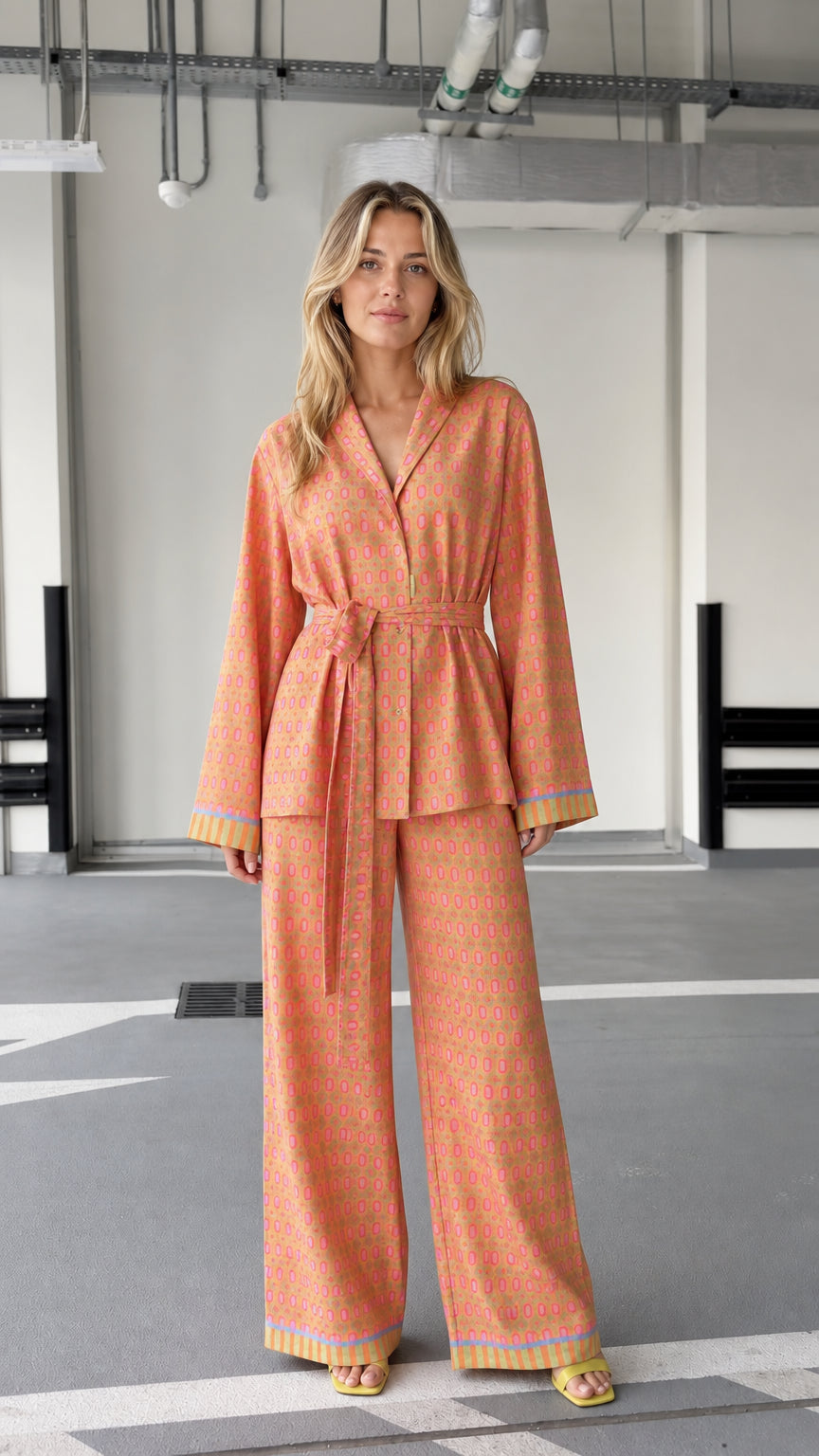 Woman wearing orange patterned two-piece lounge set, front view