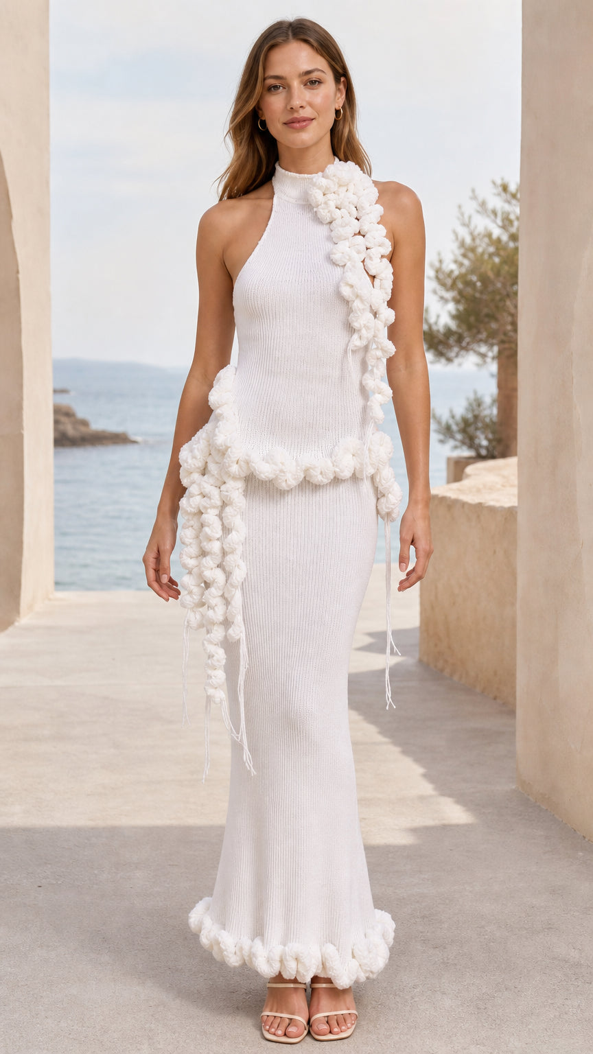 Front view of woman wearing white halter ribbed knit maxi dress with 3D pom pom trim