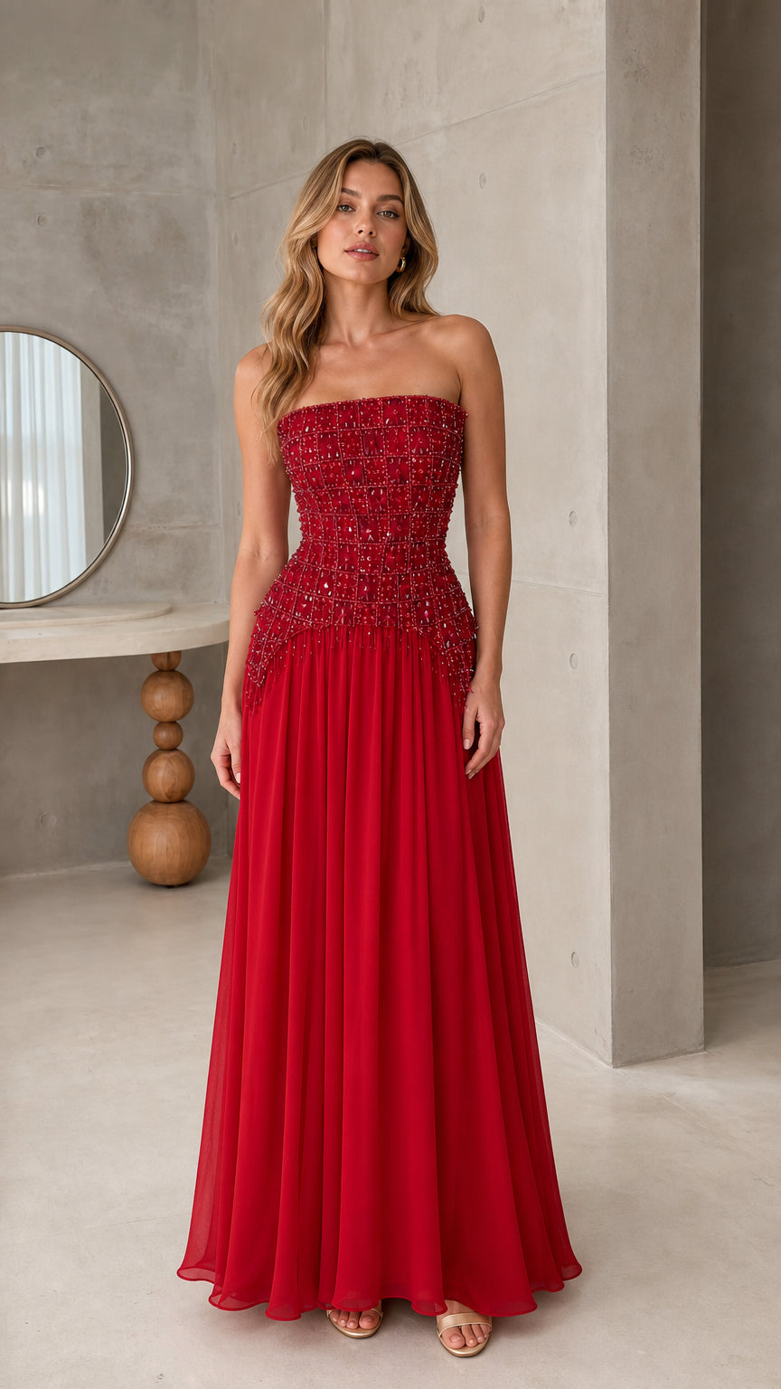 Front view of model wearing strapless ruby red beaded corset maxi evening gown