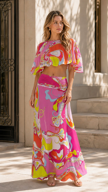 Front view of model wearing pink abstract print two-piece crop top and maxi skirt set