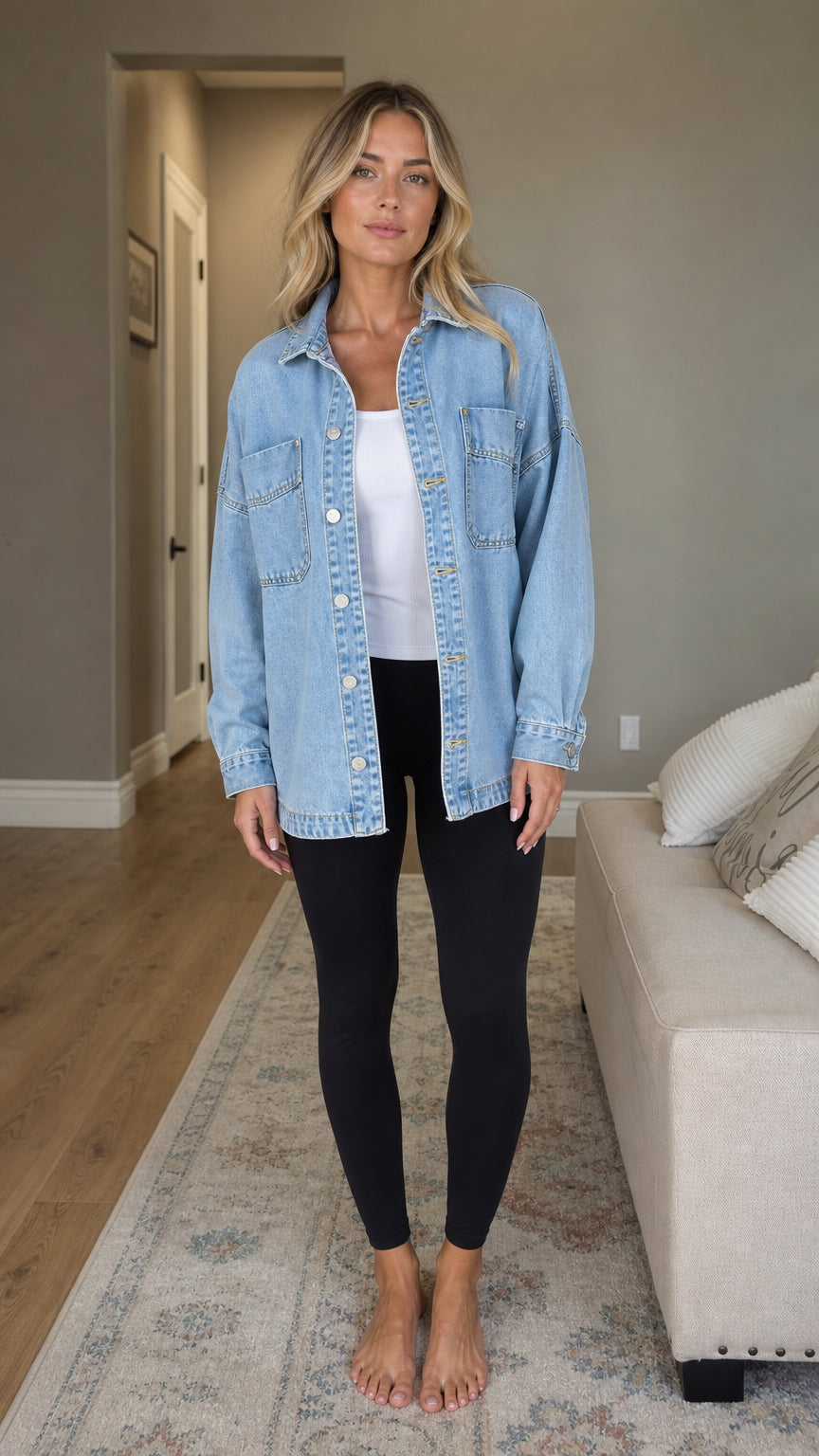 Front view of woman wearing light blue denim shacket with white top and black leggings