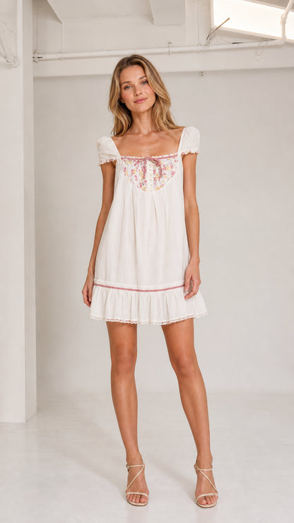 White floral bib babydoll mini dress front view on model