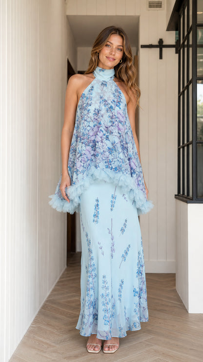 Front view of model wearing light blue floral halter maxi dress with ruffle overlay