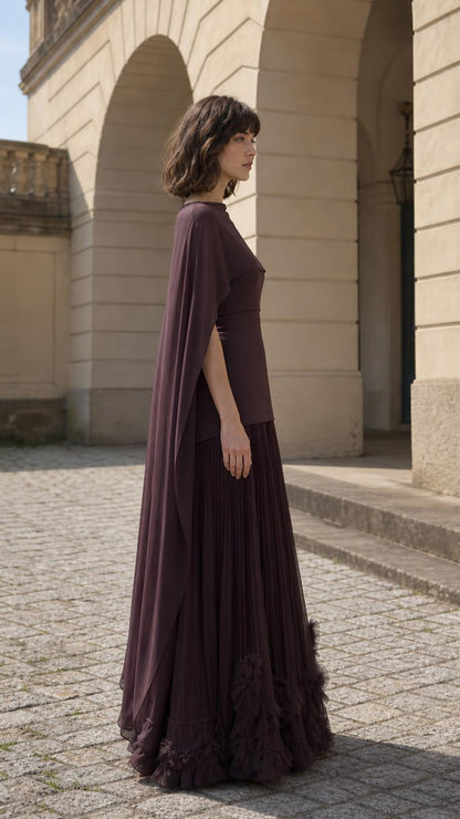 Side profile view of woman wearing plum cape maxi dress