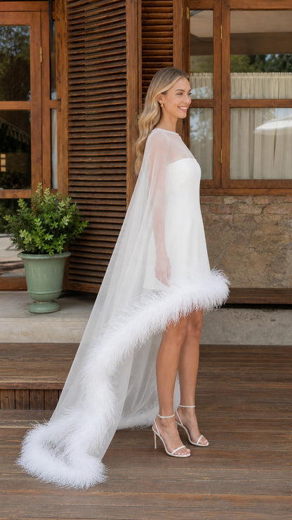 Side view of white cape mini dress showing high-low feather train