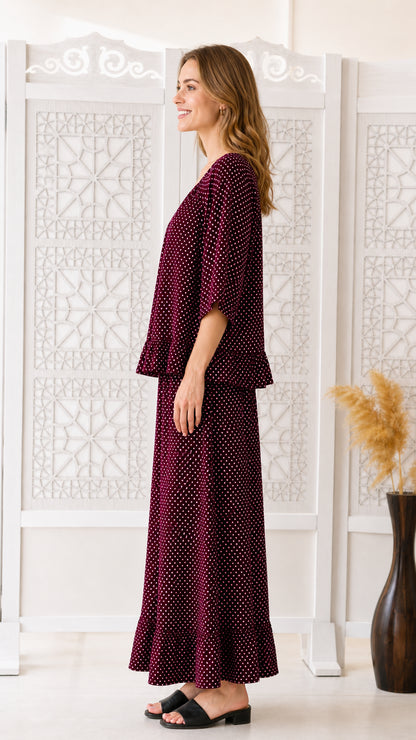 Side profile view of burgundy polka dot matching top and pants set