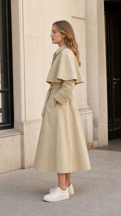 Side profile of woman wearing beige cape overlay midi trench coat