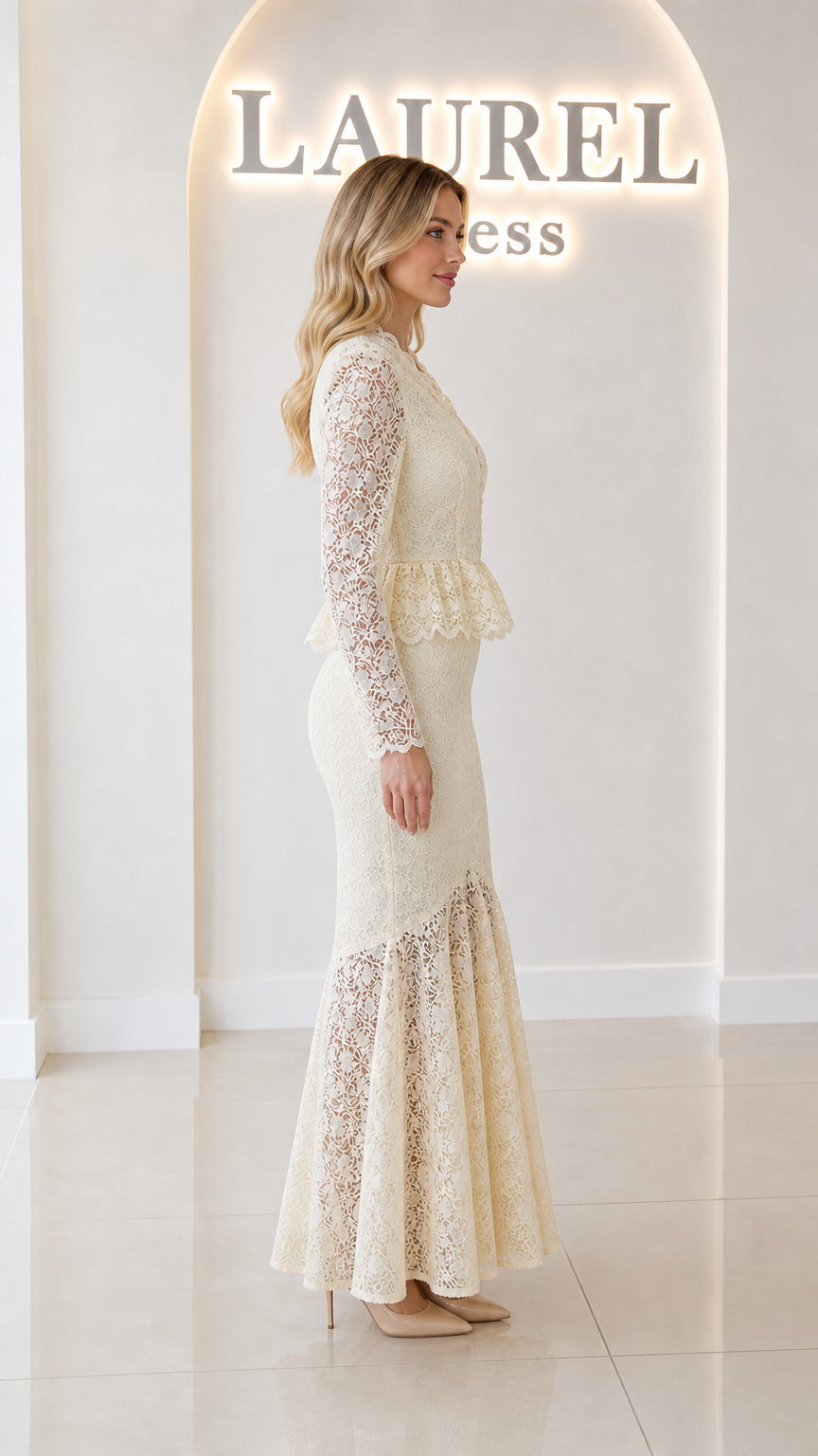 Side profile view of ivory long sleeve lace peplum gown