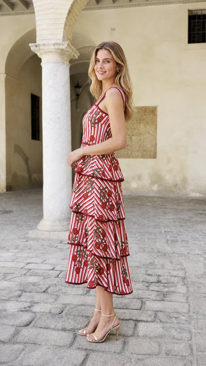 Side view of model wearing red striped dress in courtyard