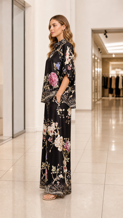 Side view of model wearing black floral print satin two piece set