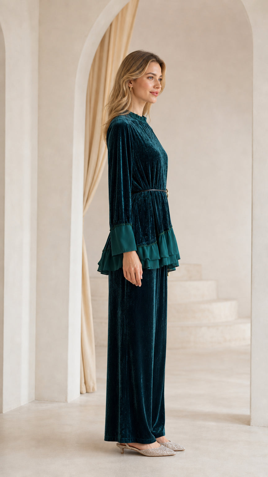 Side profile view of dark green crushed velvet tunic top and wide-leg trousers