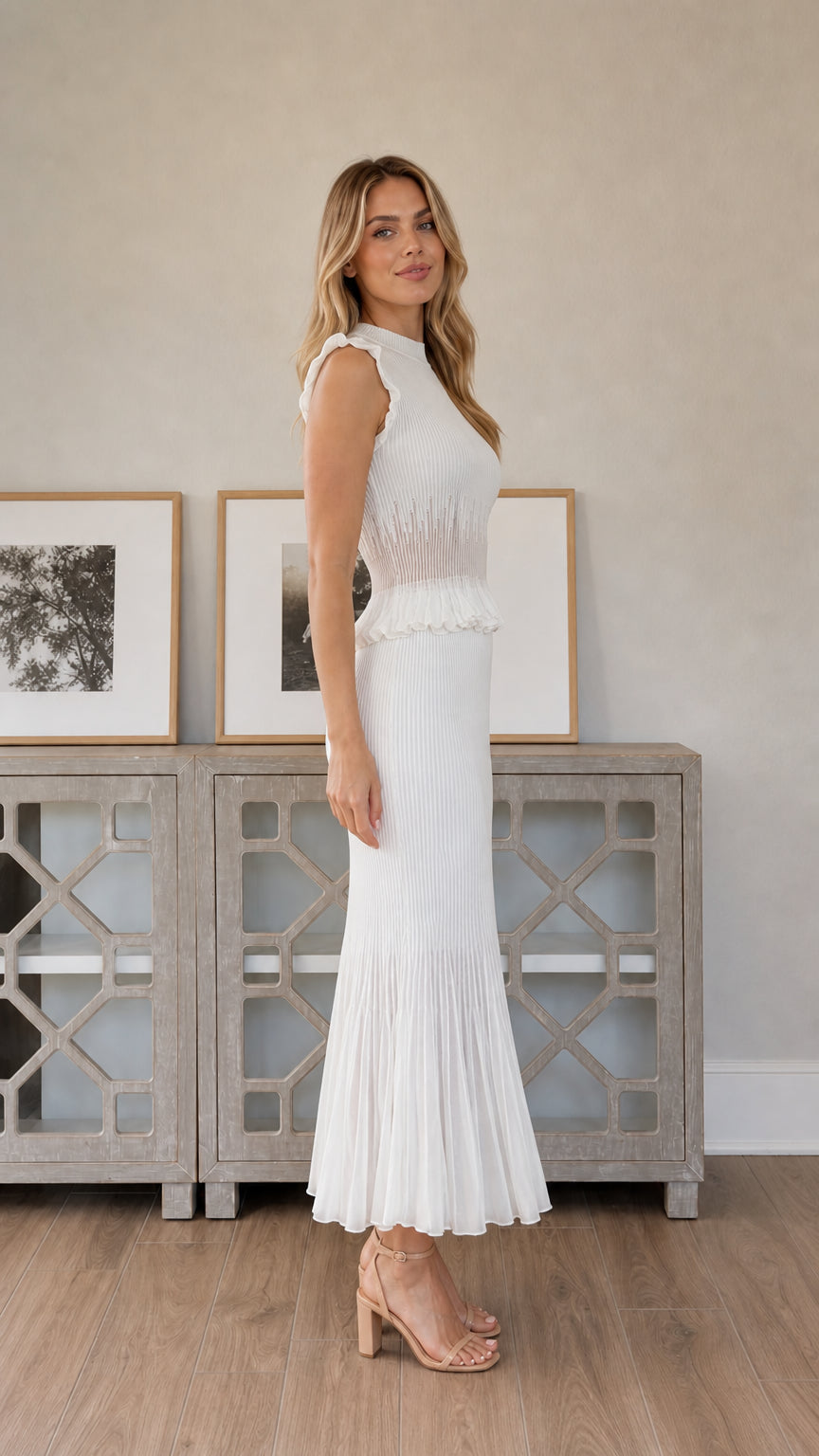 Side profile view of woman wearing white pleated midi dress