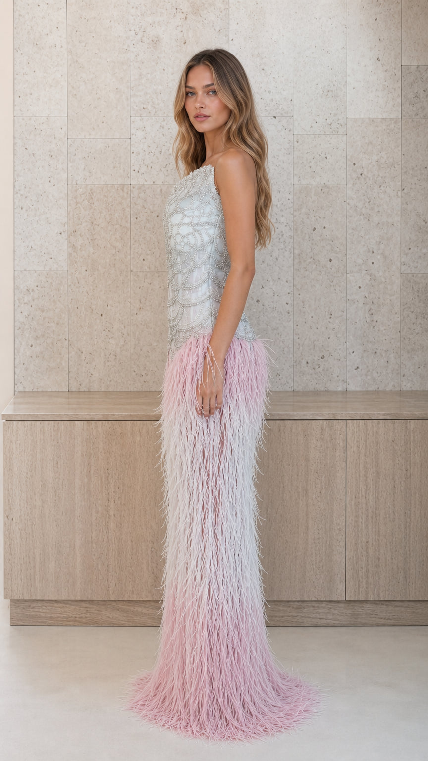 Side profile view of silver and pink feather one-shoulder evening gown