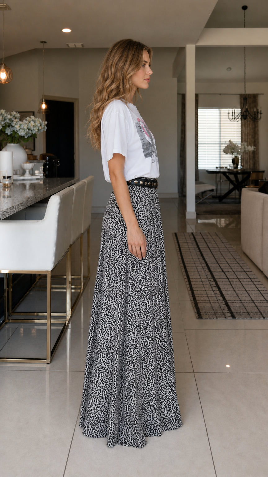 Side profile of model in white graphic tee and leopard print pants
