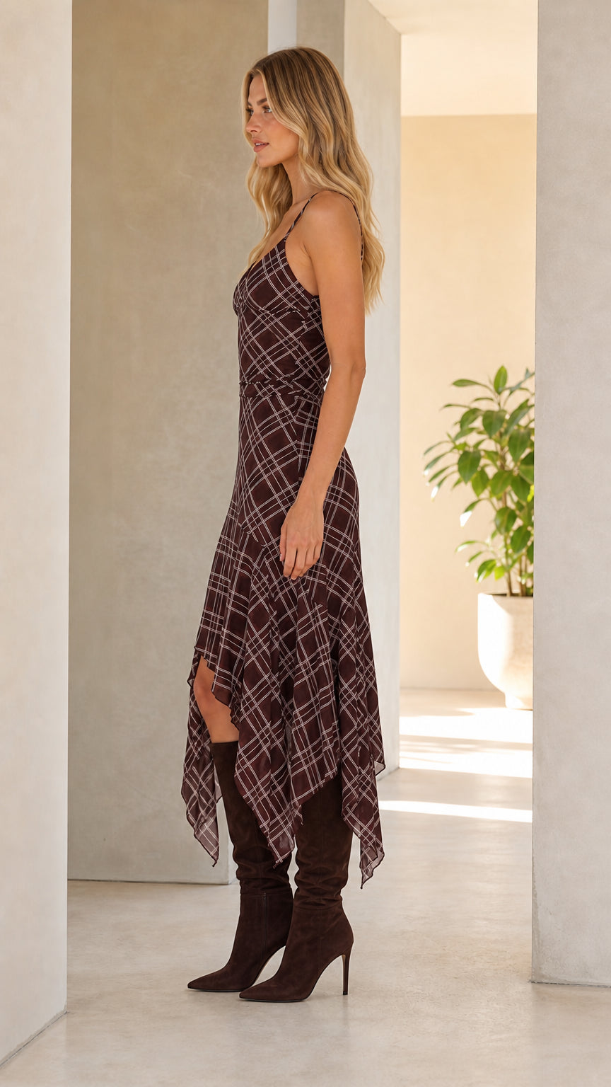 Side profile view of woman wearing brown plaid midi dress