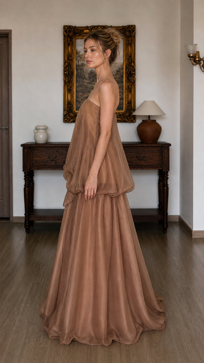 Side profile of model in brown strapless maxi dress