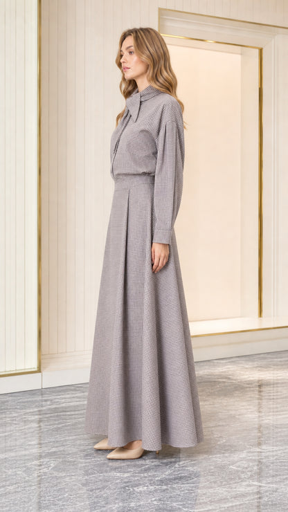 Side profile of model wearing grey houndstooth tie-neck maxi dress