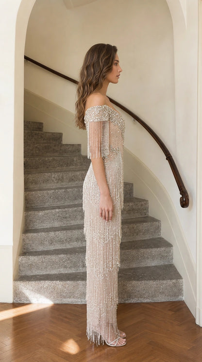 Side profile of model wearing champagne fringe evening gown