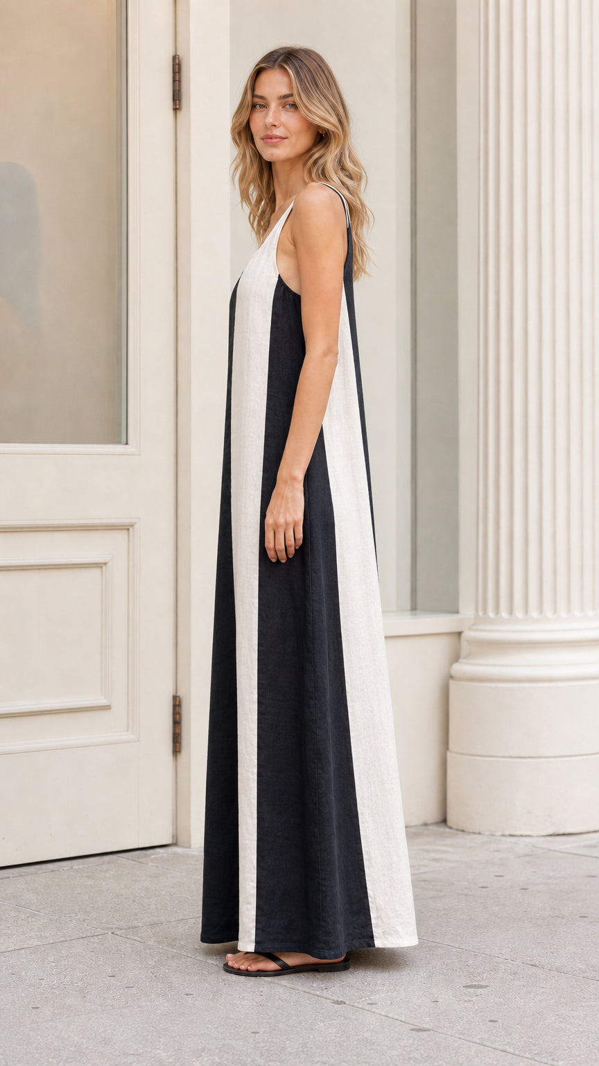 Side profile view of black and white striped maxi dress