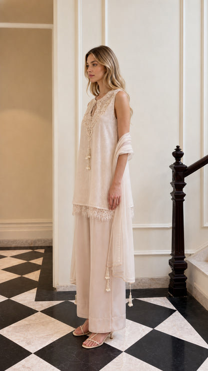 Side profile view of model in beige trouser suit set