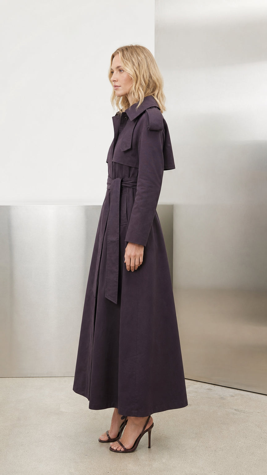 Side profile view of deep purple maxi trench coat showing structured length and lapel