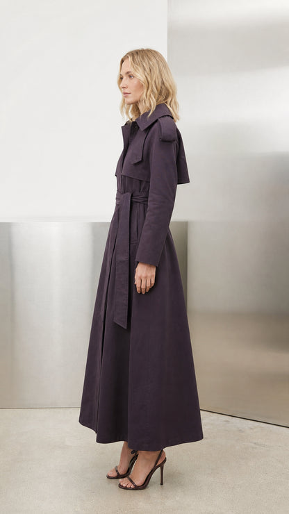 Side profile view of deep purple maxi trench coat showing structured length and lapel