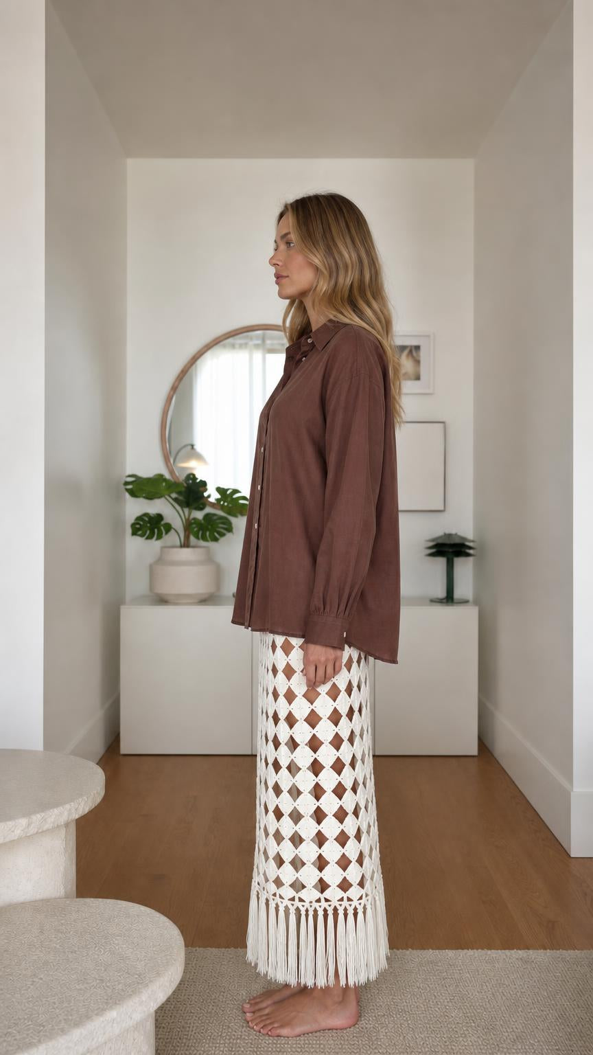 Model wearing brown long sleeve button-down shirt, side view