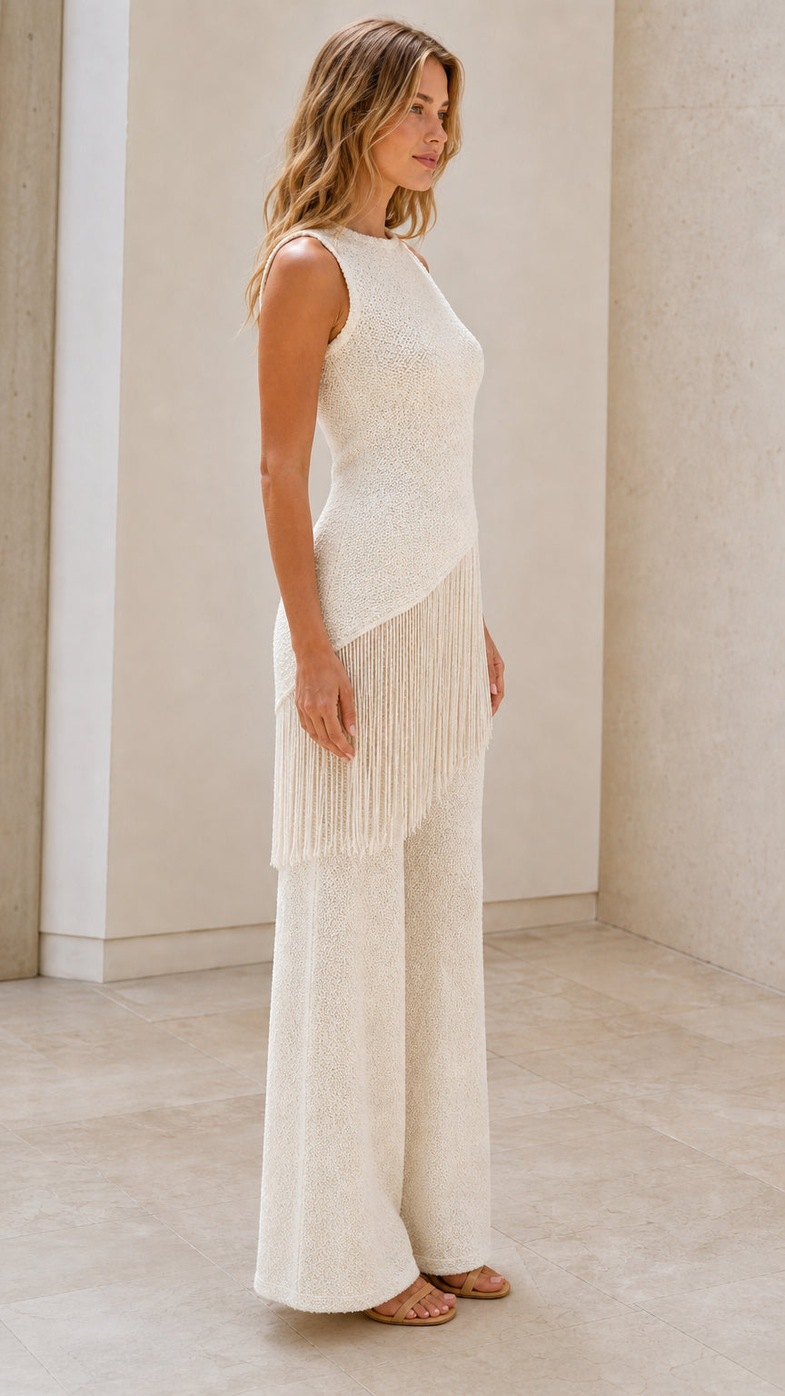 Side view of model in the cream fringe knit set
