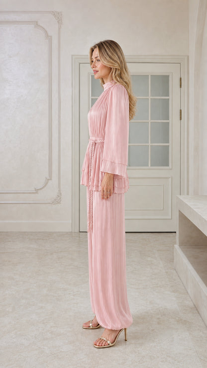 Side angle view of model wearing blush pink pleated two-piece pant set