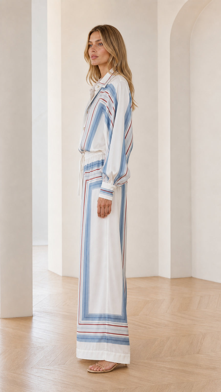 Side profile of model wearing white geometric striped outfit