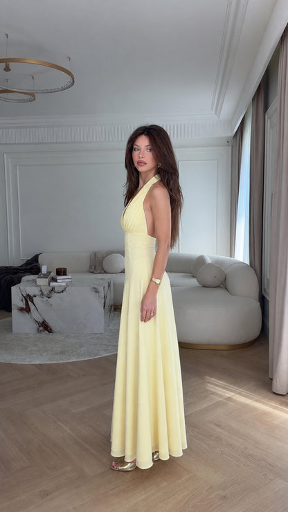 Side profile view of yellow halter maxi dress
