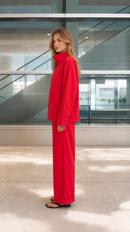 Side profile view of red utility jacket and wide-leg cuffed trousers