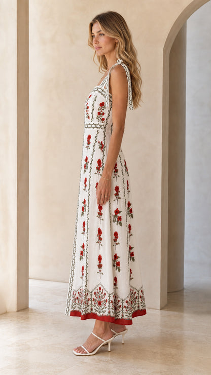 Side profile view of woman in white floral embroidered maxi dress