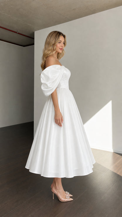 Side profile view of woman wearing white off-shoulder dress