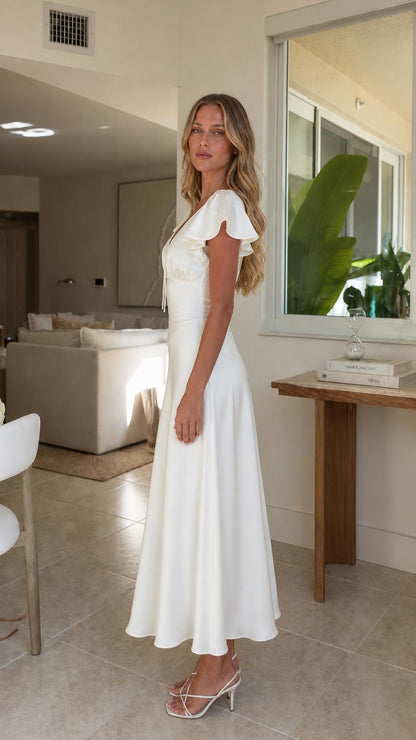 Side profile view of woman in white midi dress