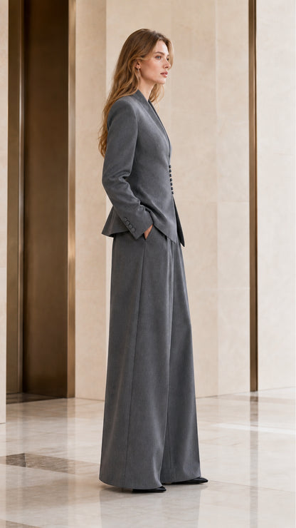 Side profile view of women's grey 2-piece suit showing fitted waist and fluid trouser silhouette