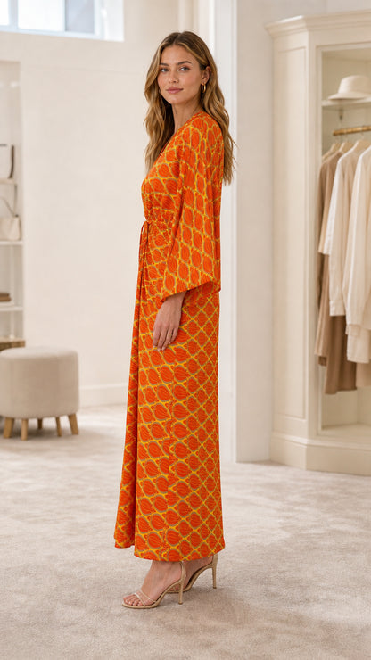 Side view of model in orange geometric print maxi dress